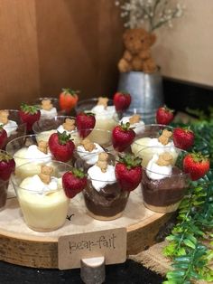 small desserts with strawberries and cream on a wooden platter in front of a teddy bear