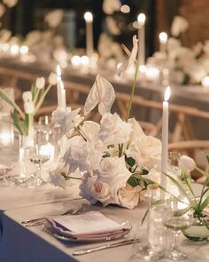 the table is set with white flowers and candles