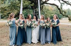 a group of women standing next to each other in front of a flag pole holding bouquets