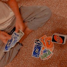 a person sitting on the floor with some cards and chips in front of them,