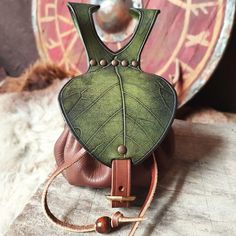 a green leaf shaped purse sitting on top of a wooden table