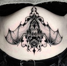 a black and white photo of a woman's stomach with an intricate design on it