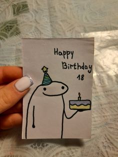 a person holding a birthday card with a cake on it and a candle in the middle