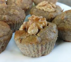 a white plate topped with muffins covered in walnuts