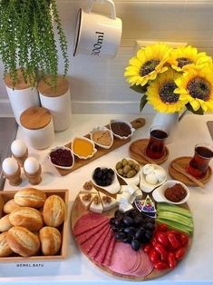 an assortment of food is displayed on a kitchen counter with sunflowers in the background