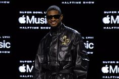 a man in a black leather jacket and sunglasses standing next to an apple music logo