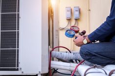 a man is working on an air conditioner