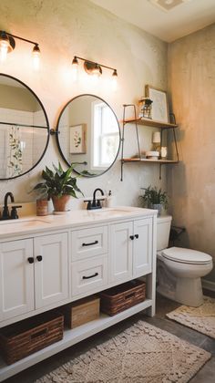 a bathroom with two round mirrors on the wall above the sink, and a toilet