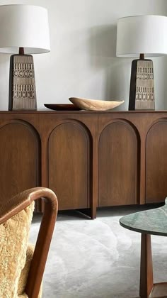 a living room filled with furniture and two lamps on top of each other's sides