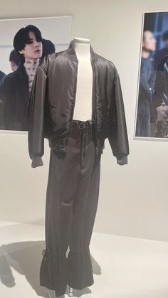 a mannequin dressed in black clothing and leather jacket on display at an art gallery