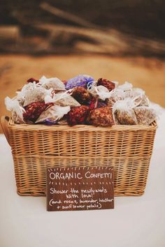 a wicker basket filled with chocolates on top of a white table next to a sign