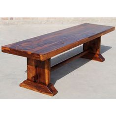 a wooden bench sitting on top of a cement floor