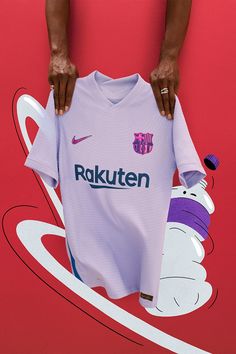 a person holding up a soccer jersey with the word rokuten on it in front of a red background