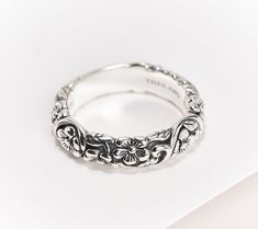 a close up view of a wedding ring on a white surface with an intricate design