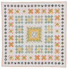 an old quilt with colorful squares and flowers on the front, in pastel colors