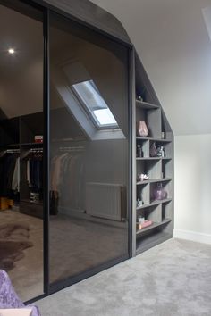 an attic bedroom with open closets and skylight