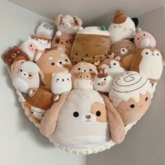 a bunch of stuffed animals that are in the shape of a heart on a wall