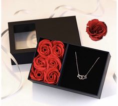 a black box with red roses in it and a rose on the other side,