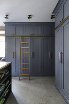 a room with blue cabinets and a ladder