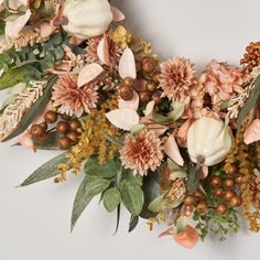 an arrangement of flowers and leaves on a white background