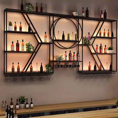 a wall mounted shelf filled with lots of bottles on top of a wooden counter next to a bar