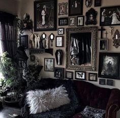 a living room filled with lots of framed pictures on the wall and a couch in front of it