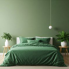 a bed with green sheets and pillows next to two potted plants on either side