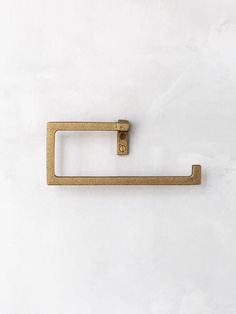 an old brass towel ring on a white wall