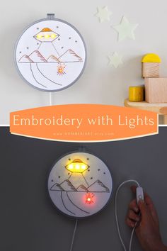 a hand holding a remote control next to a clock with lights on it and the words embroidery with lights written below