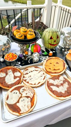 a table topped with pancakes covered in icing next to pumpkins and jack - o'- lanterns