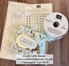 some crafting supplies are laying out on a wooden surface with a ribbon and tag