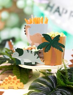 an assortment of food items displayed on a table with green plants and fake trees in the background