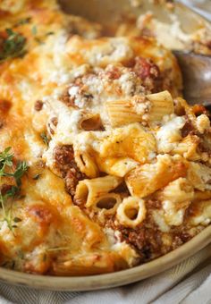 a bowl filled with pasta and meat covered in cheese