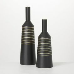 two black vases with gold lines on them