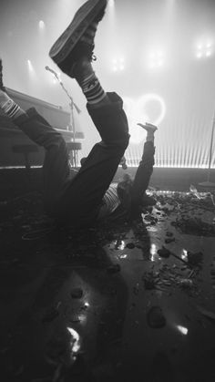 a man laying on the ground with an umbrella over his head in front of a stage