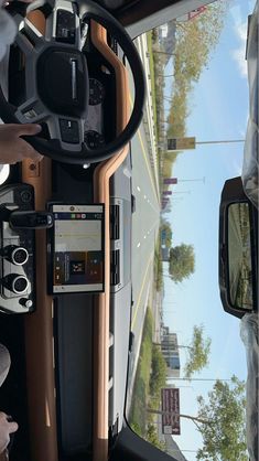 the driver's seat of a bus is shown with an electronic device on the dashboard