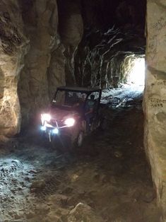 a jeep driving through a cave filled with rocks