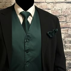 a man wearing a suit and tie with a green lapel coat on top of a mannequin's head