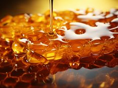 honey is being poured into a glass bowl