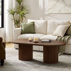 This modern coffee table blends sleek design with versatile functionality. Its features a full solid wood base, adding texture and a touch of craftsmanship to the piece. Tall Coffee Table, Oval Coffee Table, Living Room Aesthetic, Oval Coffee Tables, Sofa End Tables, The Ivy, Modern Coffee Table, Living Room Coffee Table, Contemporary Living Room