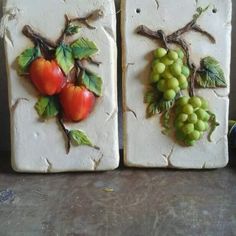 two white tiles with fruit on them sitting next to each other