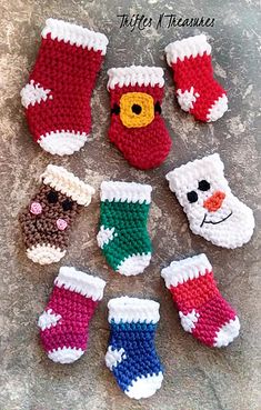 crocheted christmas stockings and mittens are arranged on the ground