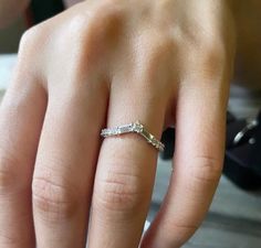 a close up of a person's hand with a diamond ring on their finger