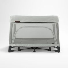 a baby crib with the top closed and side panels folded down, on a white background