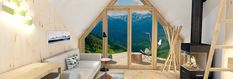 a living room with wooden floors and a large window that looks out onto the mountains