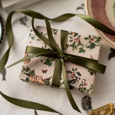 a wrapped present sitting on top of a table next to other plates and utensils