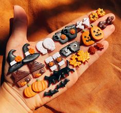 a person's hand is full of halloween decorations