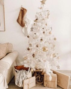 a white christmas tree with presents under it