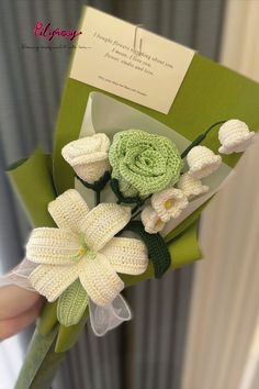 a person holding a bouquet of flowers in front of a card with the words congratulations written on it