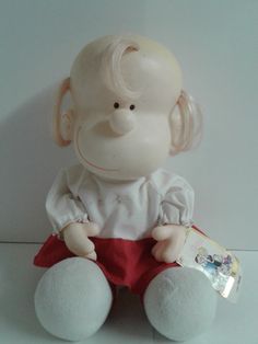 a white doll with blonde hair sitting on the floor